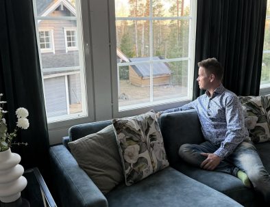 Mies istuu sohvalla Iltatähden vuokrahuvilan suurten ikkunoiden äärellä Muuramessa