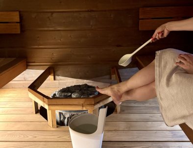 Saunoja löylykauha kädessään Iltatähden saunan lauteilla